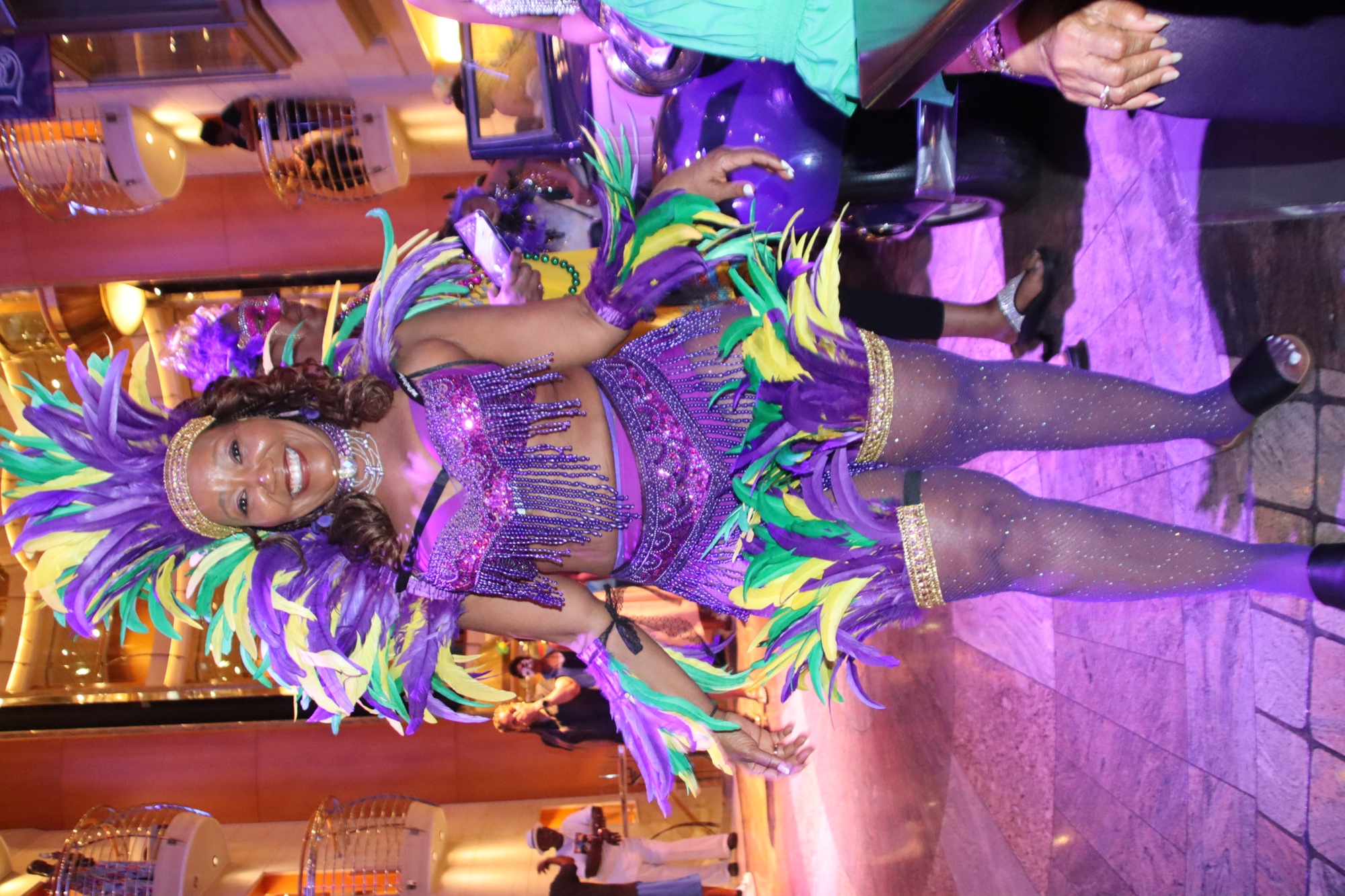 A guest in a colorful carnival costume celebrating aboard a cruise ship